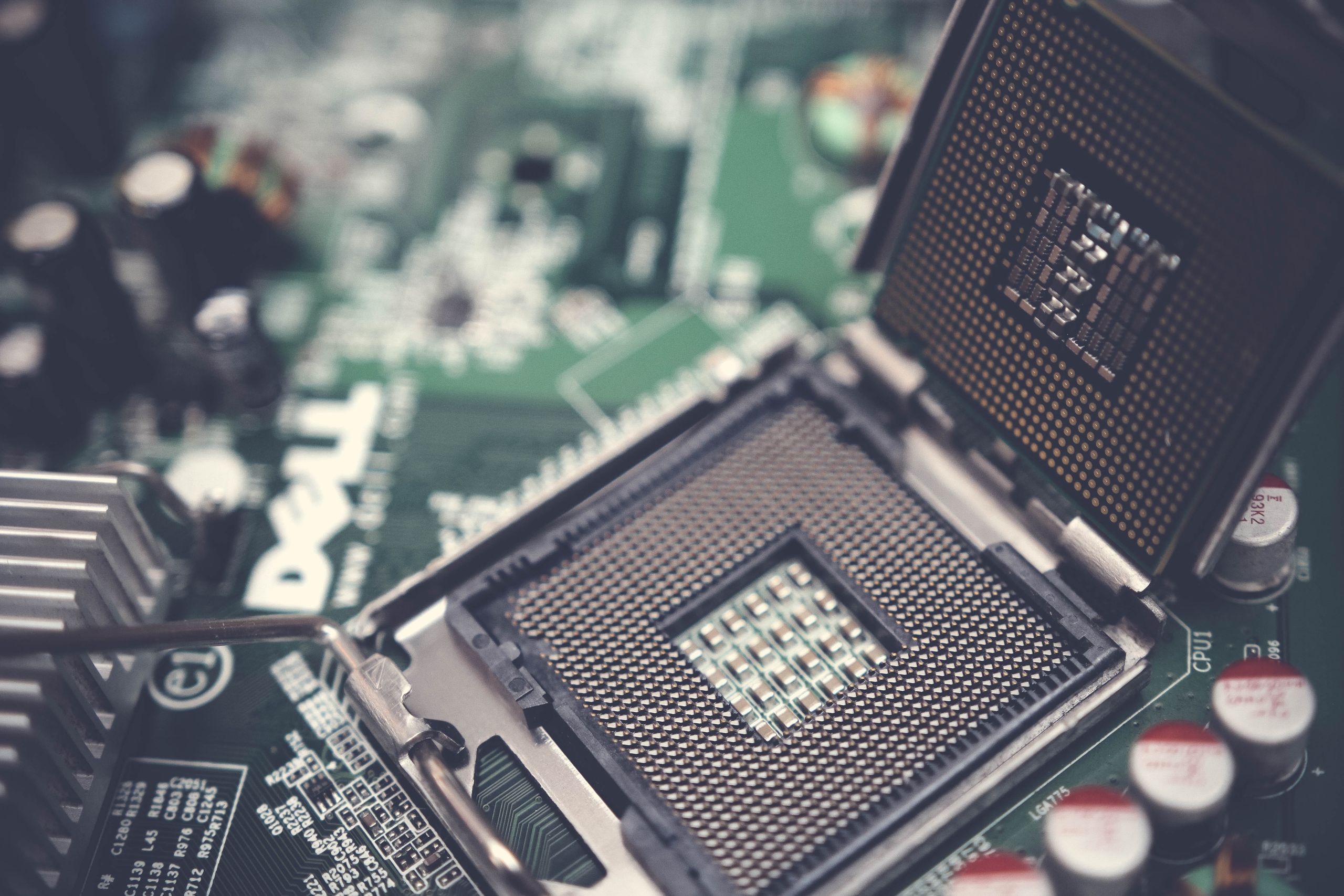 Detailed view of a CPU socket on a green motherboard, showcasing microprocessor technology.